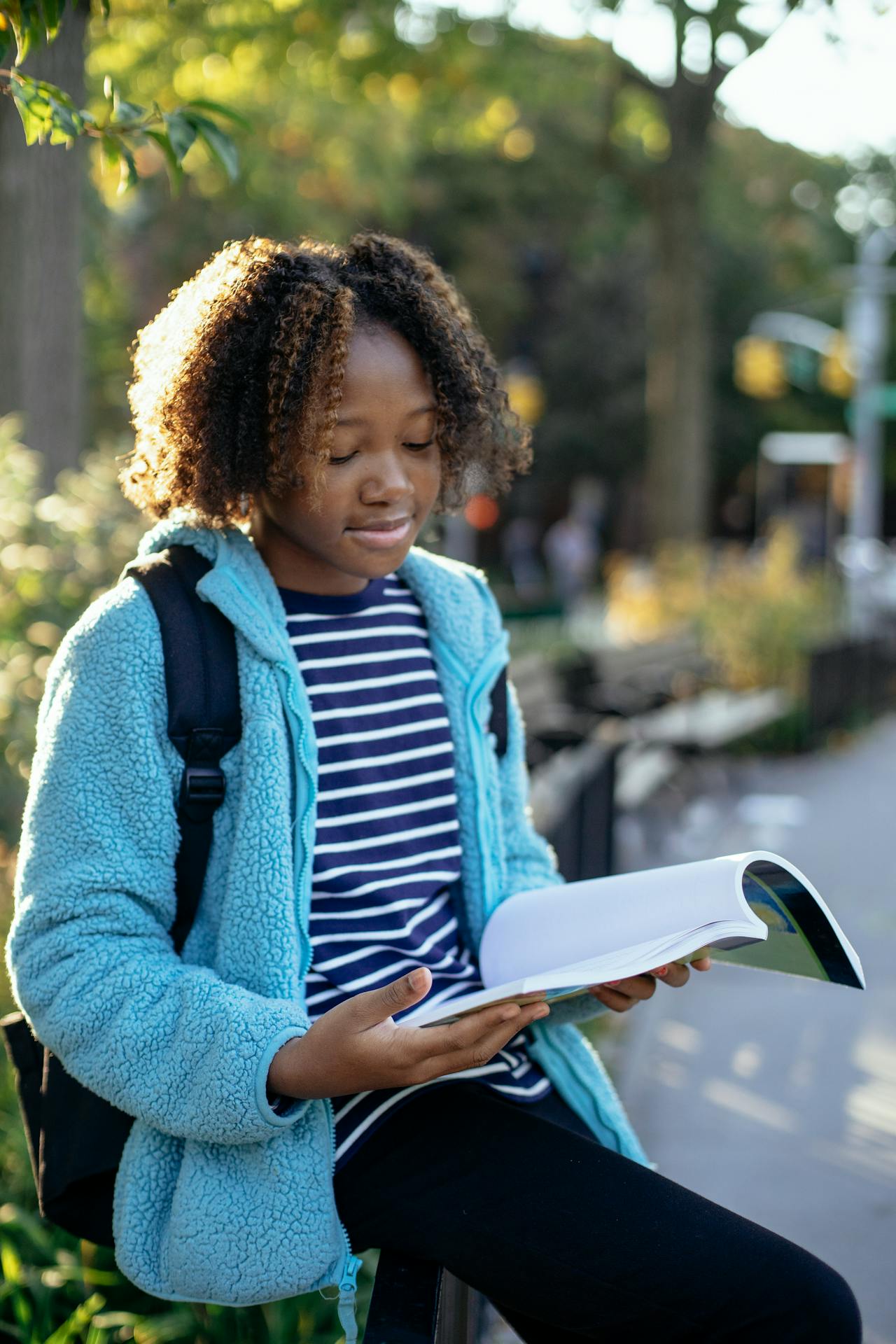 Young student reading a book outdoors